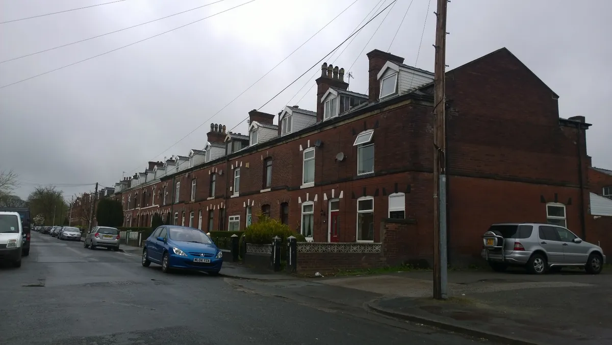 A long red-brick terrace with dormer windows on Egerton Road in Whitefield